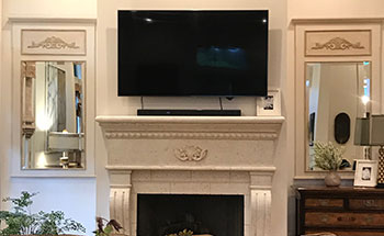 Photo of two trumeau mirrors made by Rick Samson flanking a fireplace.